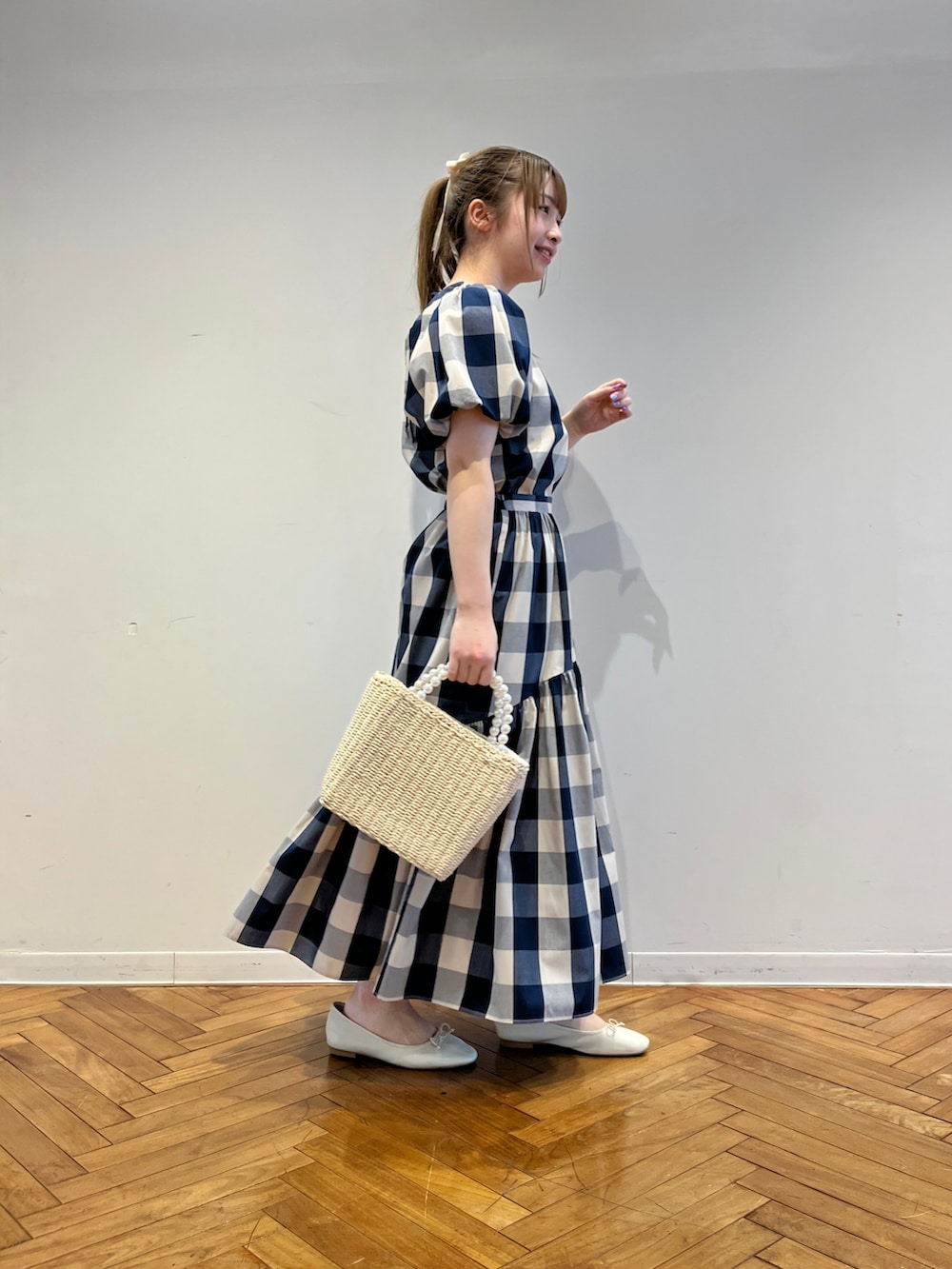 ブルー系のシャツ/ブラウス、ブルー系のスカート、ホワイト系のパンプスを着用したレディースの春コーディネートの2枚目の写真