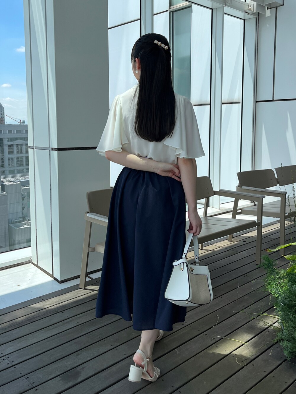 ホワイト系のシャツ/ブラウス、ブルー系のスカートを着用したレディースの春コーディネートの2枚目の写真