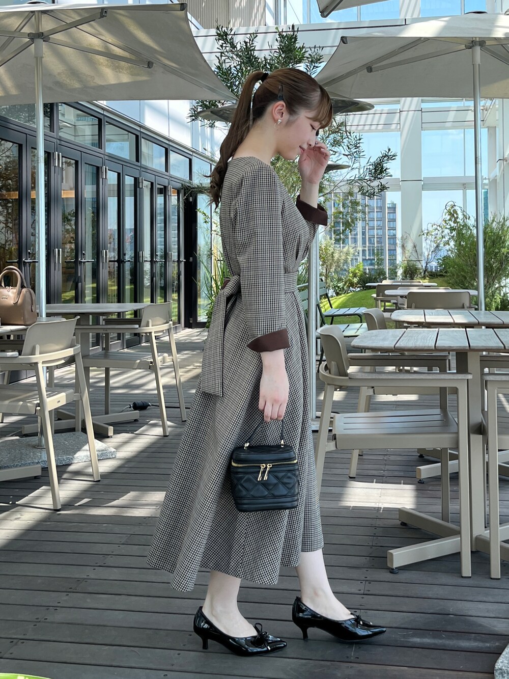 ベージュ系のワンピースを着用したレディースの秋コーディネートの2枚目の写真