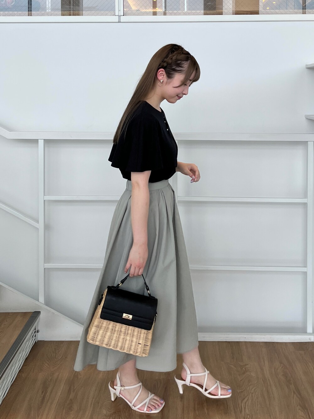 ブラック系のショルダーバッグ、ホワイト系のサンダル、ブラック系のTシャツ/カットソーを着用したレディースの夏コーディネートの2枚目の写真