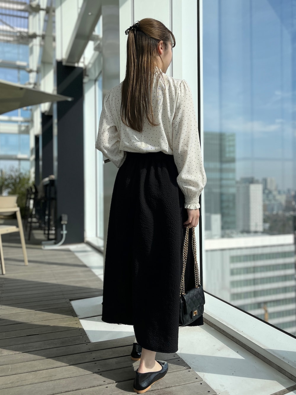 ホワイト系のシャツ/ブラウス、ブラック系のスカート、ブラック系のショルダーバッグを着用したレディースの冬コーディネートの3枚目の写真