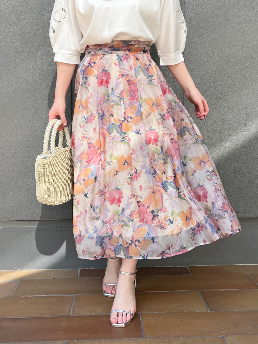 ホワイト系のTシャツ/カットソー、オレンジ系のスカートを着用したレディースの春コーディネートの4枚目の写真