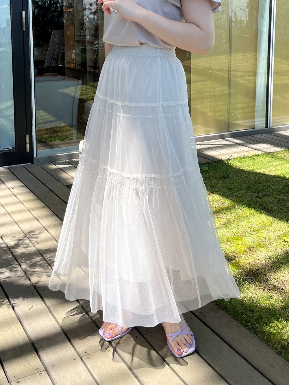 グレー系のTシャツ/カットソー、ホワイト系のスカート、グレー系のショルダーバッグを着用したレディースの夏コーディネートの5枚目の写真