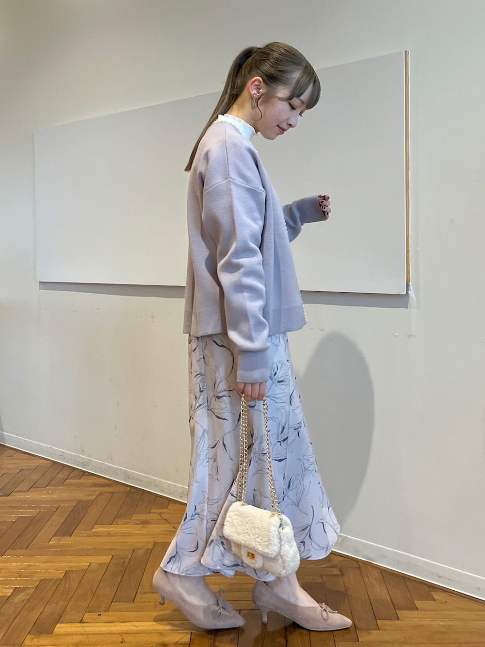 ブルー系のカーディガン/ボレロ、ベージュ系のスカート、ホワイト系のTシャツ/カットソーを着用したレディースの秋コーディネートの2枚目の写真