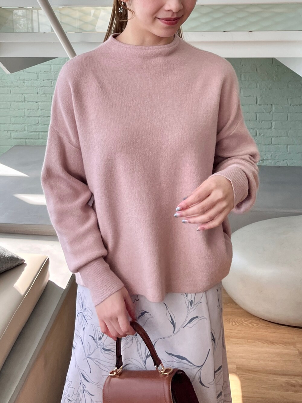 ピンク系のニット/セーター、ベージュ系のスカート、イエロー系のショルダーバッグを着用したレディースの秋コーディネートの3枚目の写真