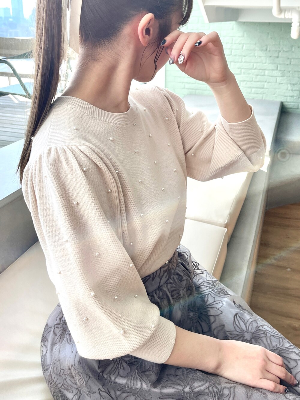 ホワイト系のニット/セーター、ベージュ系のその他アウター、グレー系のスカートを着用したレディースの冬コーディネートの5枚目の写真