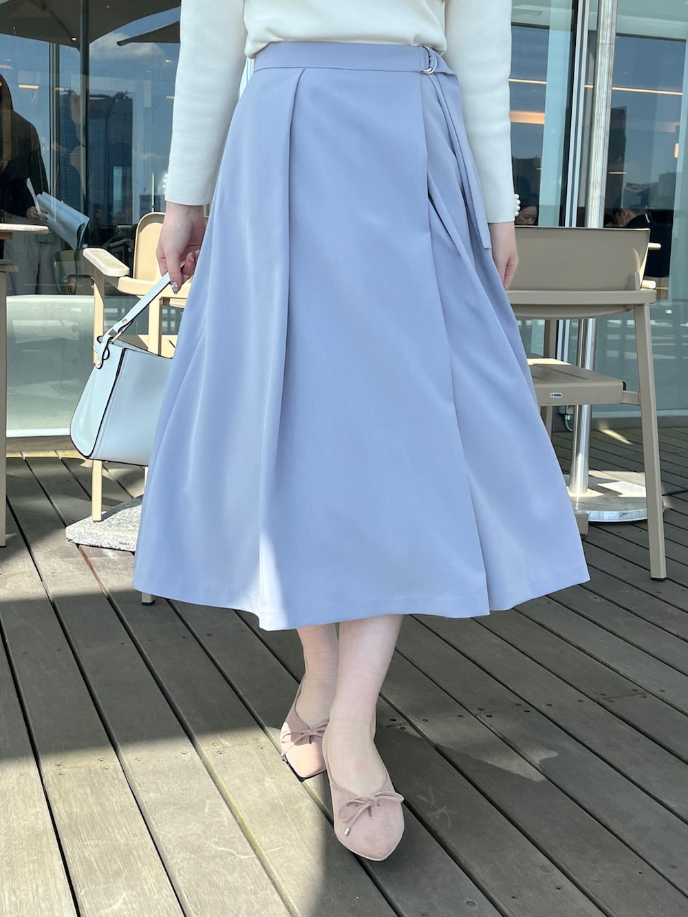 ホワイト系のニット/セーター、ブルー系のスカートを着用したレディースの春コーディネートの5枚目の写真