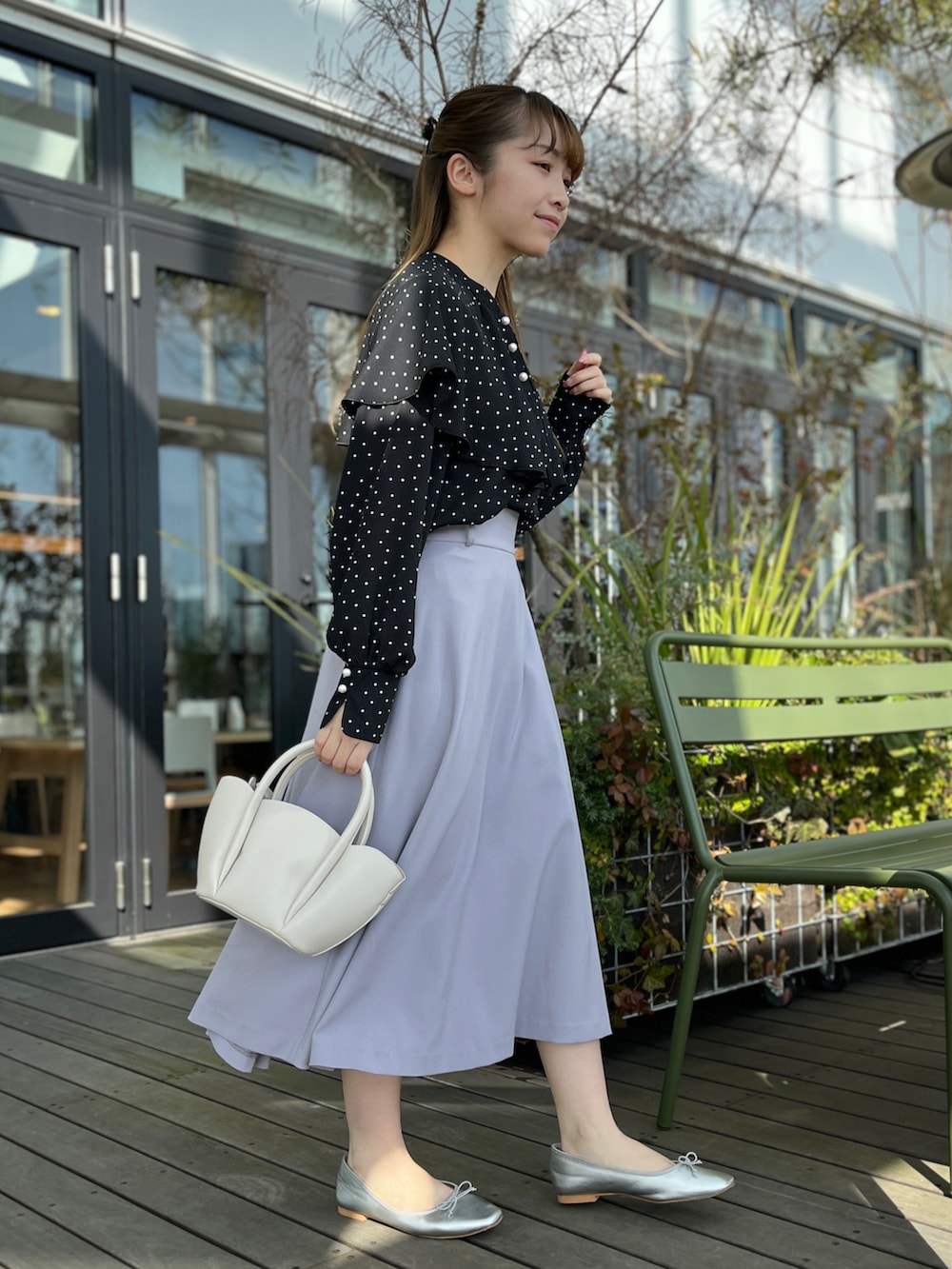 ブラック系のシャツ/ブラウス、ブルー系のスカート、ホワイト系のショルダーバッグを着用したレディースの冬コーディネートの2枚目の写真