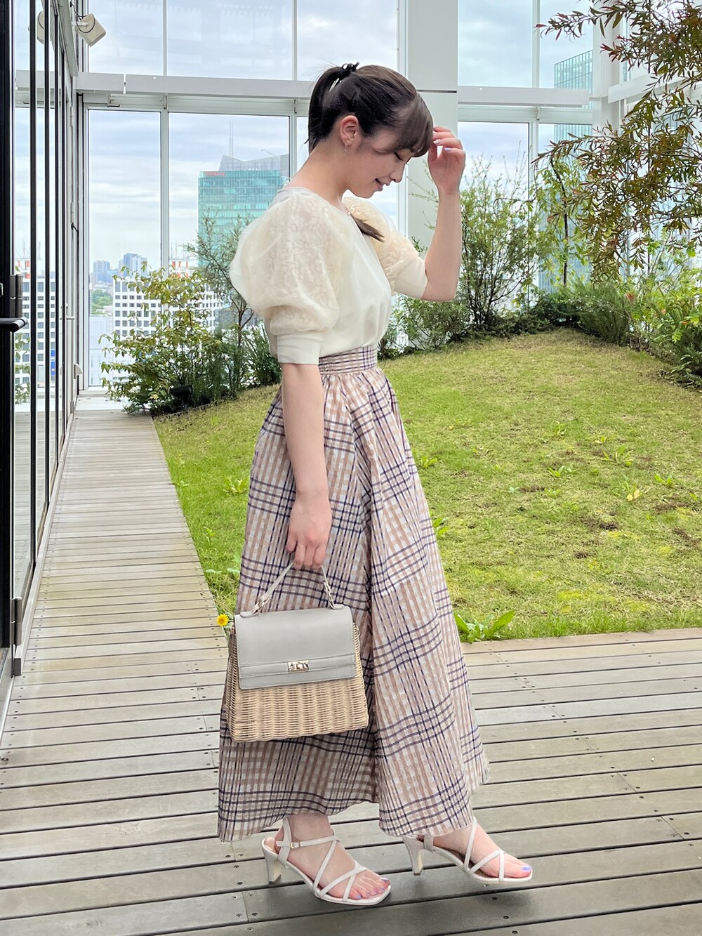 ホワイト系のニット/セーター、グレー系のショルダーバッグ、ホワイト系のサンダルを着用したレディースの夏コーディネートの2枚目の写真