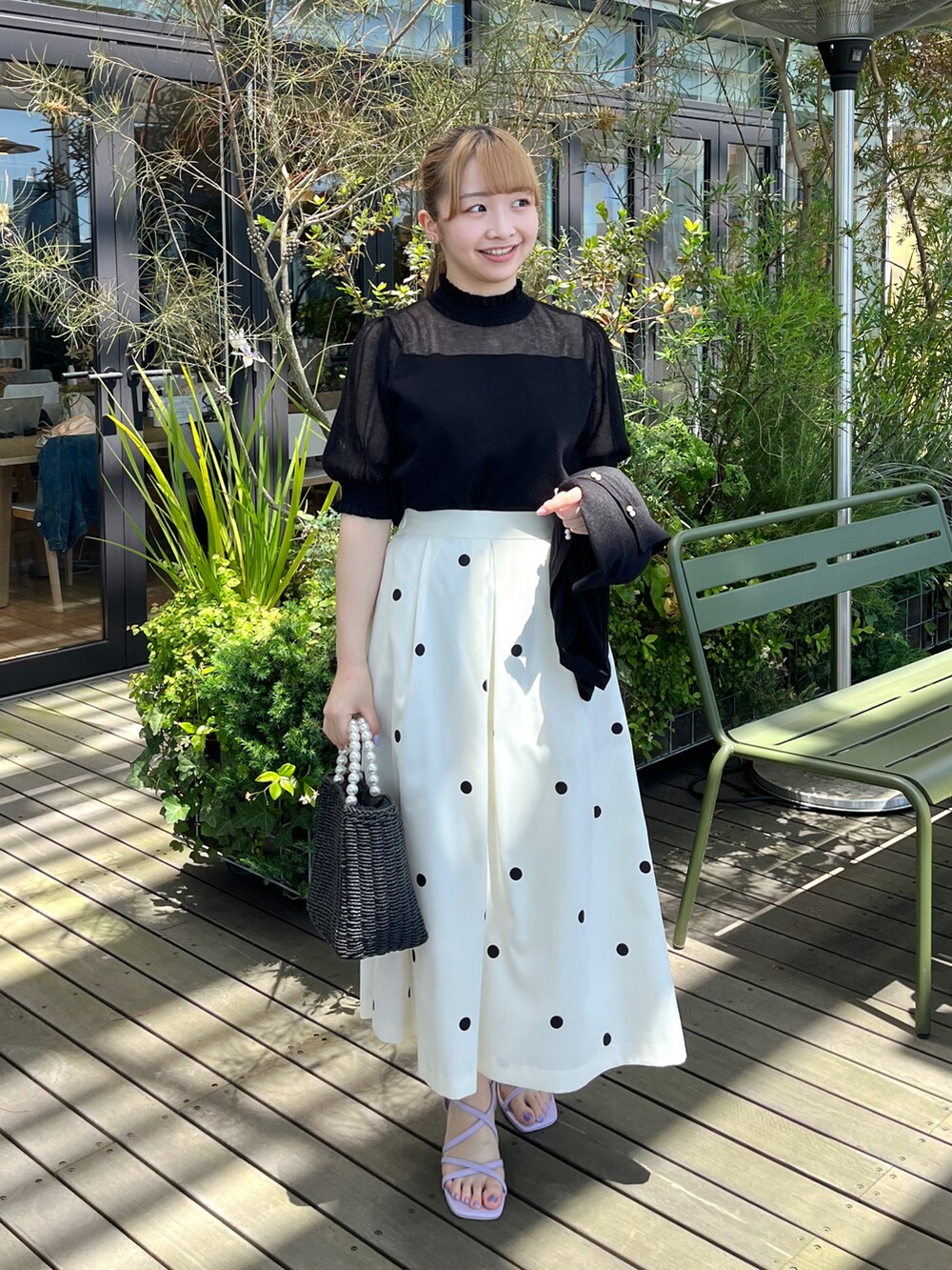 ブラック系のニット/セーター、ブラック系のカーディガン/ボレロ、ブラック系のハンドバッグを着用したレディースの夏コーディネートの5枚目の写真