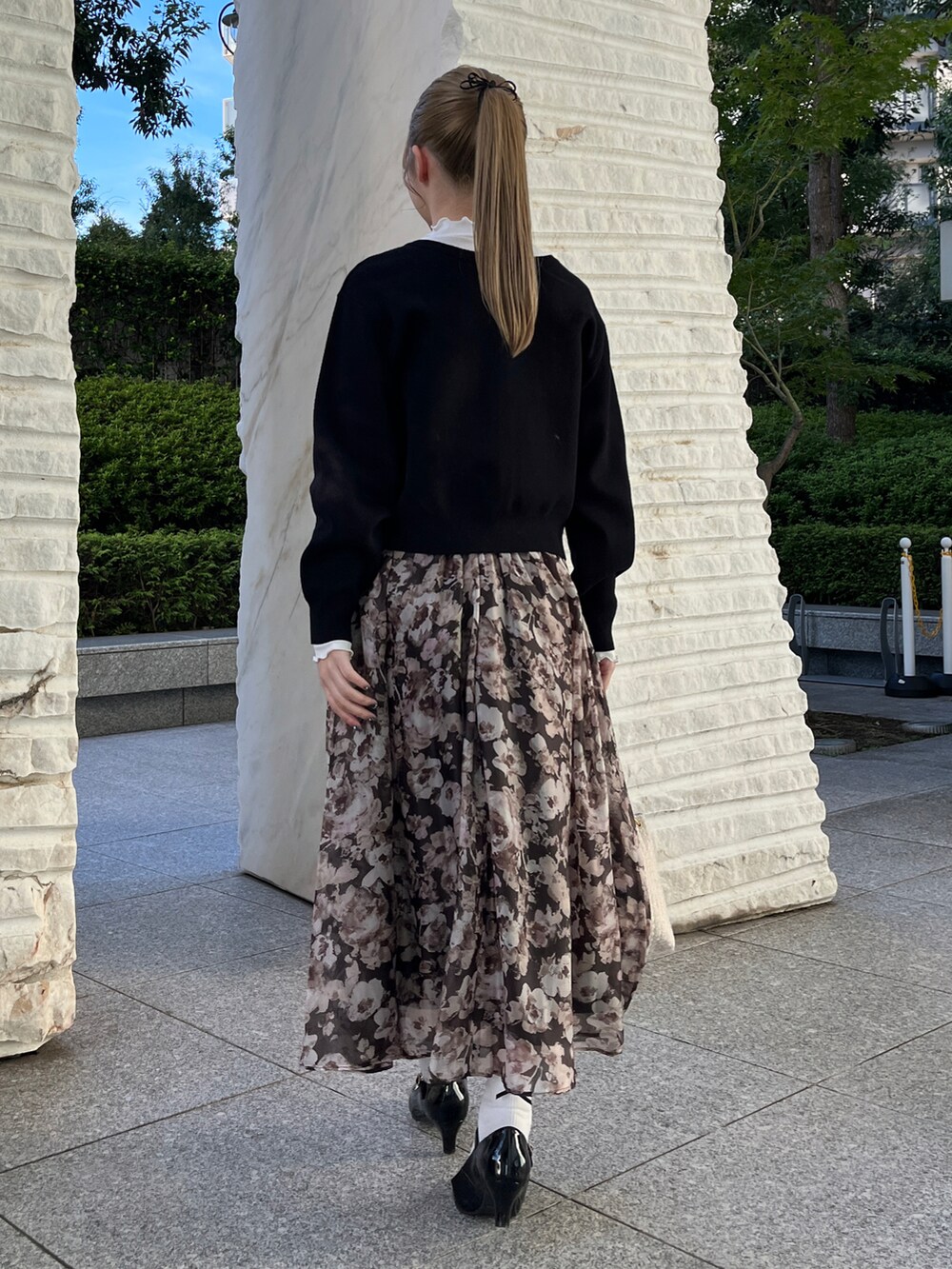 ブラック系のカーディガン/ボレロ、ブラウン系のスカート、ホワイト系のショルダーバッグを着用したレディースの秋コーディネートの3枚目の写真