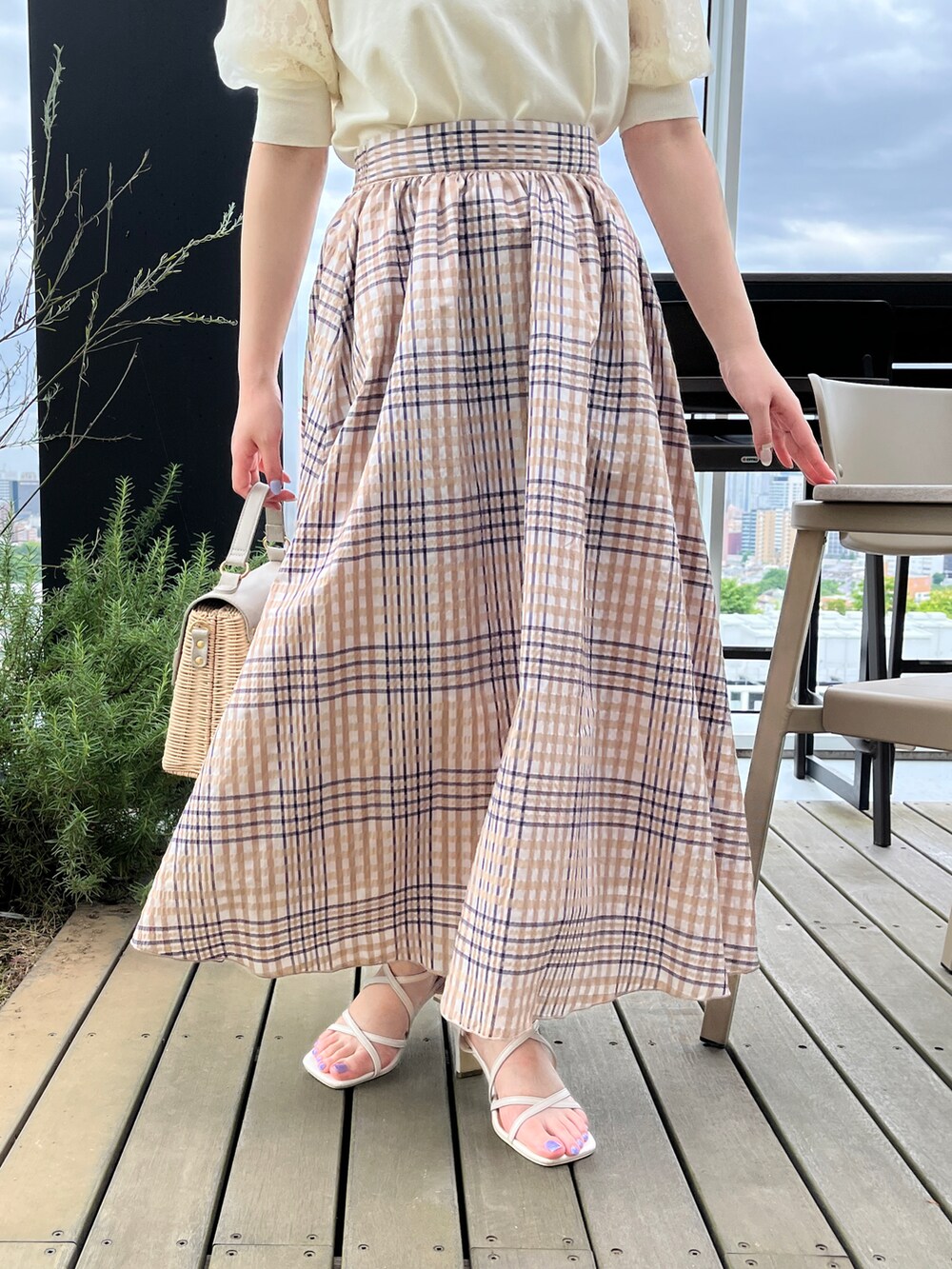 ホワイト系のニット/セーター、グレー系のショルダーバッグ、ホワイト系のサンダルを着用したレディースの夏コーディネートの5枚目の写真