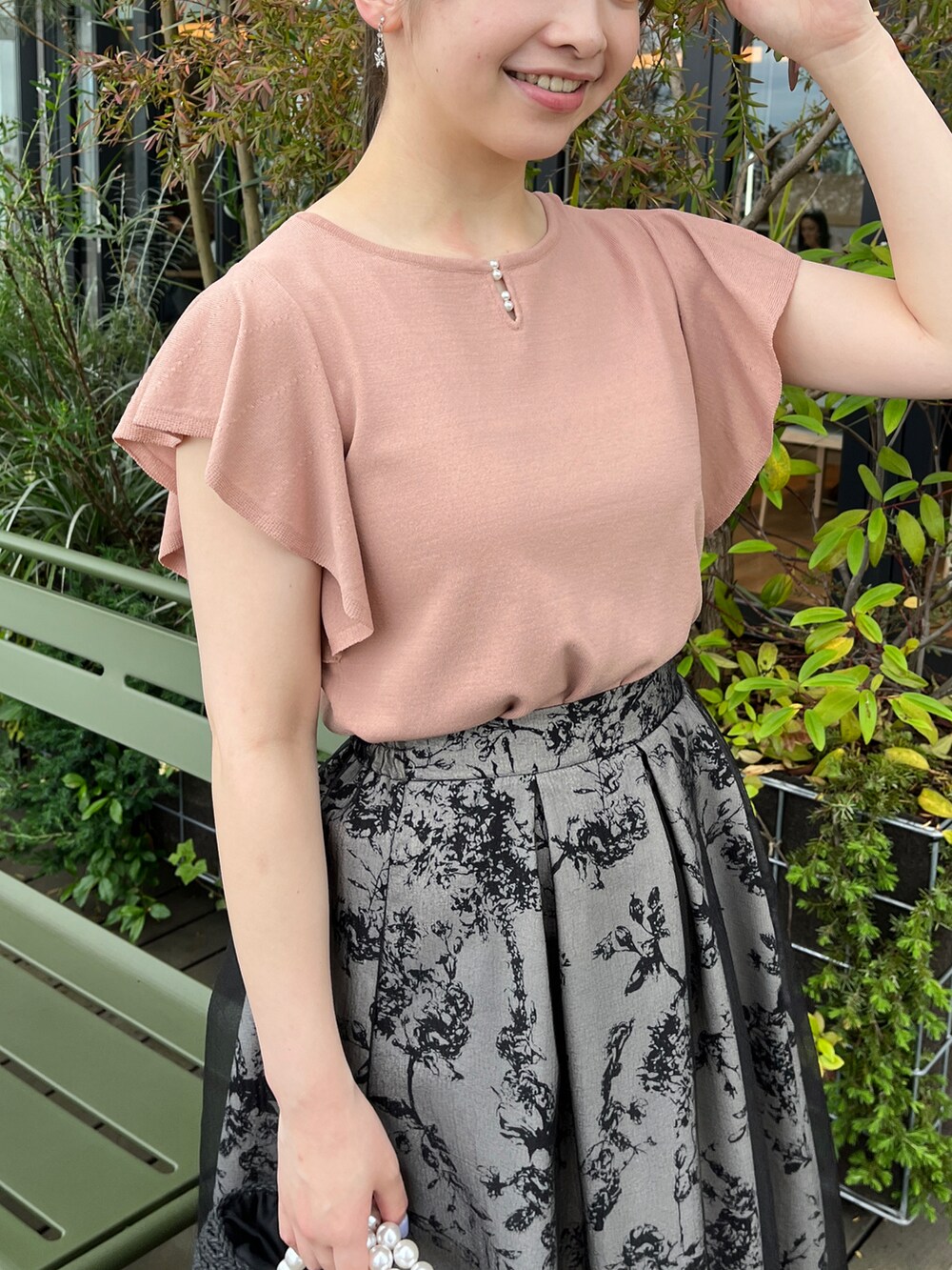 ブラック系のハンドバッグ、ブラック系のサンダル、ピンク系のニット/セーターを着用したレディースの夏コーディネートの4枚目の写真