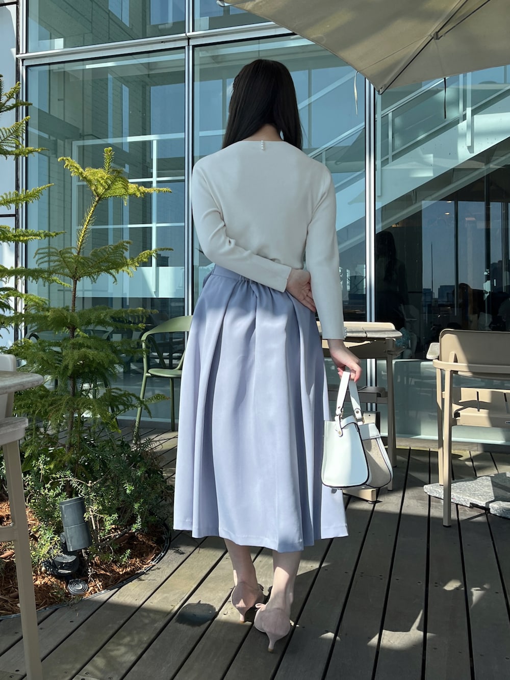 ホワイト系のニット/セーター、ブルー系のスカートを着用したレディースの春コーディネートの3枚目の写真