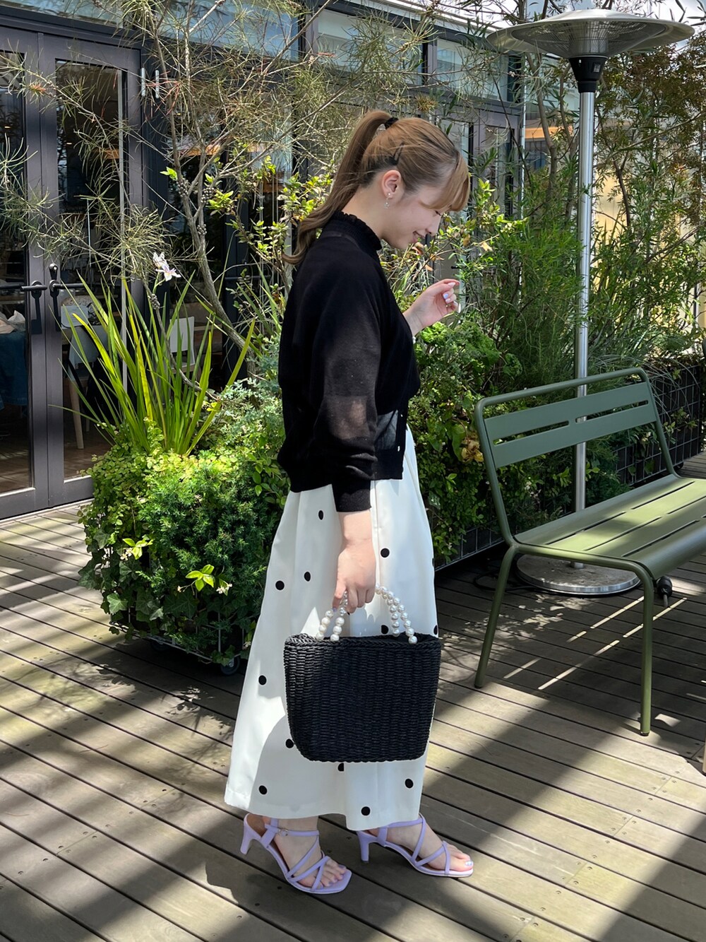 ブラック系のニット/セーター、ブラック系のカーディガン/ボレロ、ブラック系のハンドバッグを着用したレディースの夏コーディネートの2枚目の写真