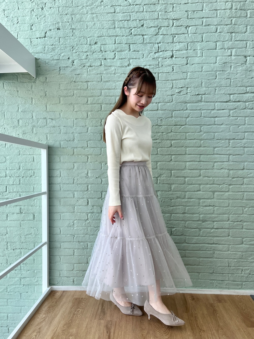 ホワイト系のTシャツ/カットソー、グレー系のスカートを着用したレディースの冬コーディネートの2枚目の写真