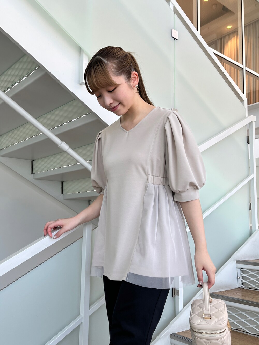 グレー系のチュニック、ブルー系のその他パンツ、ホワイト系のショルダーバッグを着用したレディースの夏コーディネートの4枚目の写真