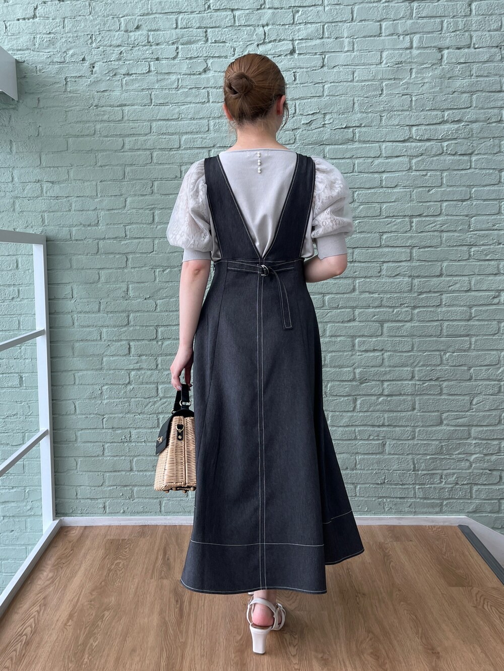 グレー系のニット/セーター、ブラック系のスカート、ブラック系のショルダーバッグを着用したレディースの夏コーディネートの3枚目の写真