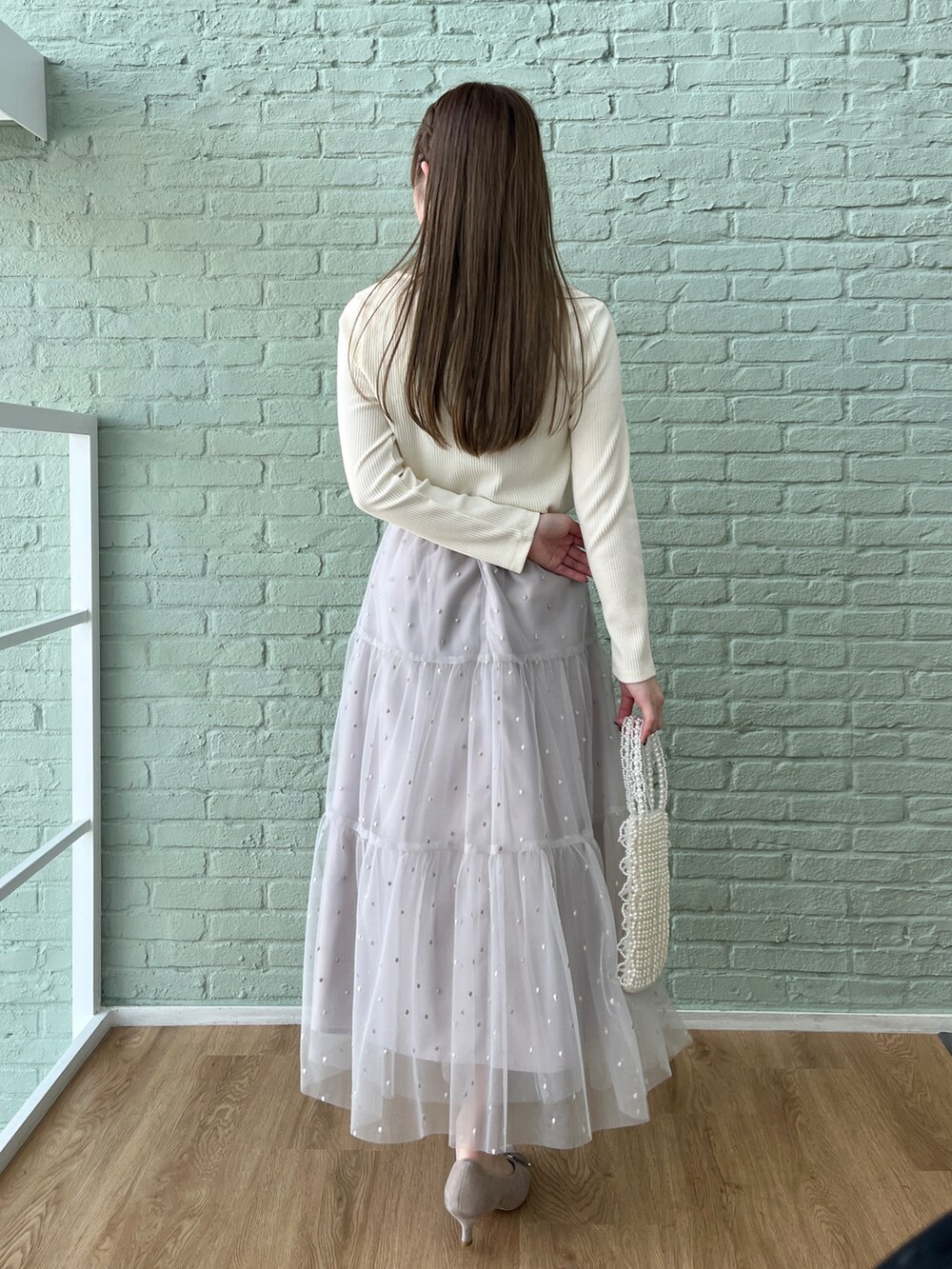 ホワイト系のTシャツ/カットソー、グレー系のスカートを着用したレディースの冬コーディネートの3枚目の写真