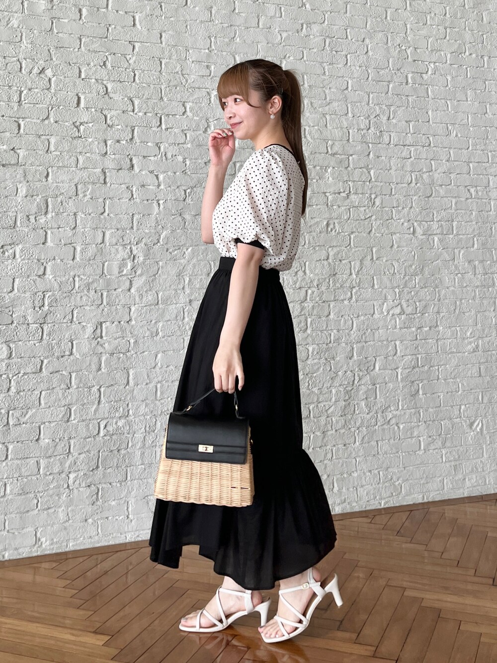 ベージュ系のシャツ/ブラウス、ブラック系のスカート、ブラック系のショルダーバッグを着用したレディースの夏コーディネートの2枚目の写真