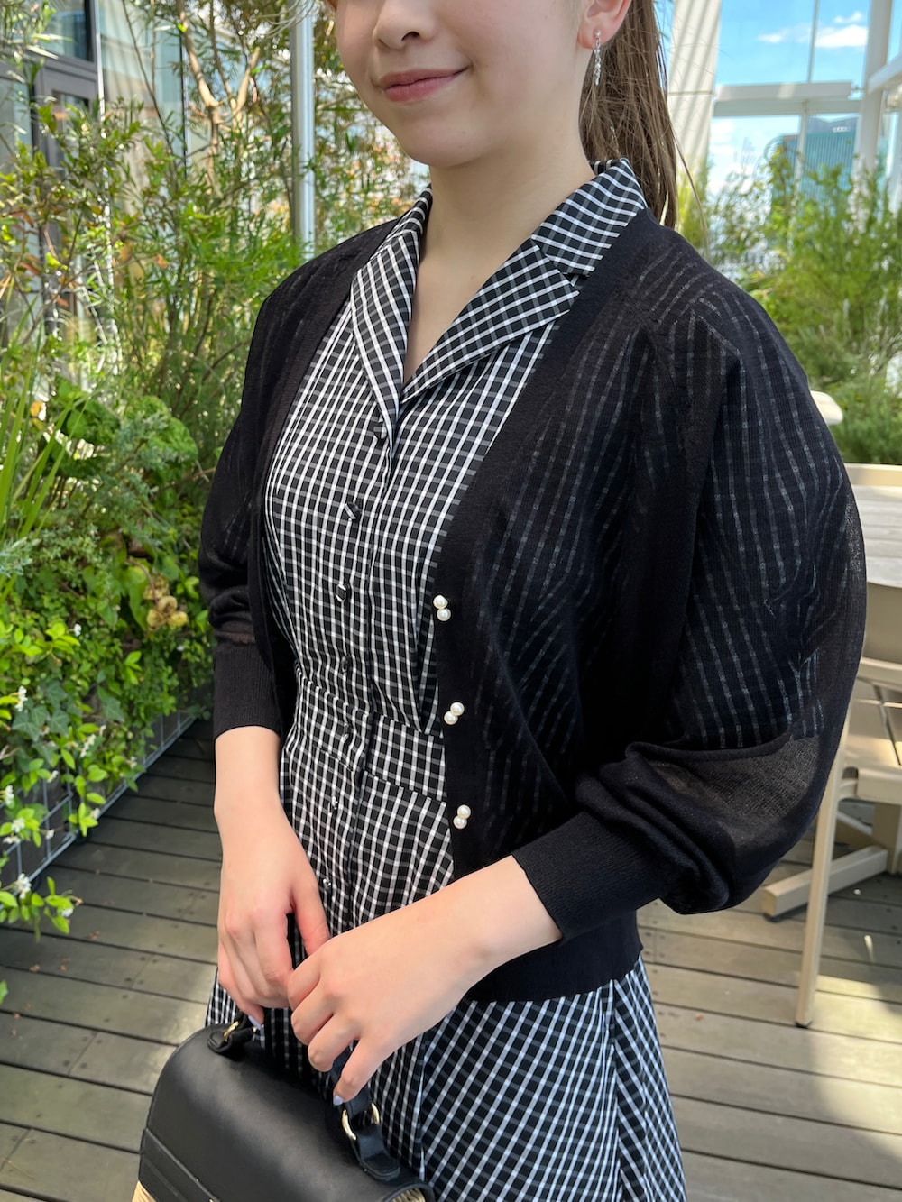 ブラック系のカーディガン/ボレロ、ブラック系のショルダーバッグ、ブラック系のサンダルを着用したレディースの夏コーディネートの4枚目の写真