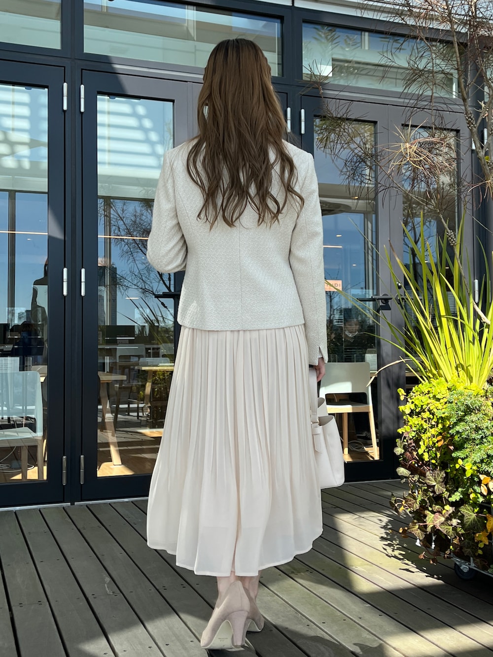 ベージュ系のノーカラージャケット、ホワイト系のスカート、ベージュ系のパンプスを着用したレディースの冬コーディネートの3枚目の写真