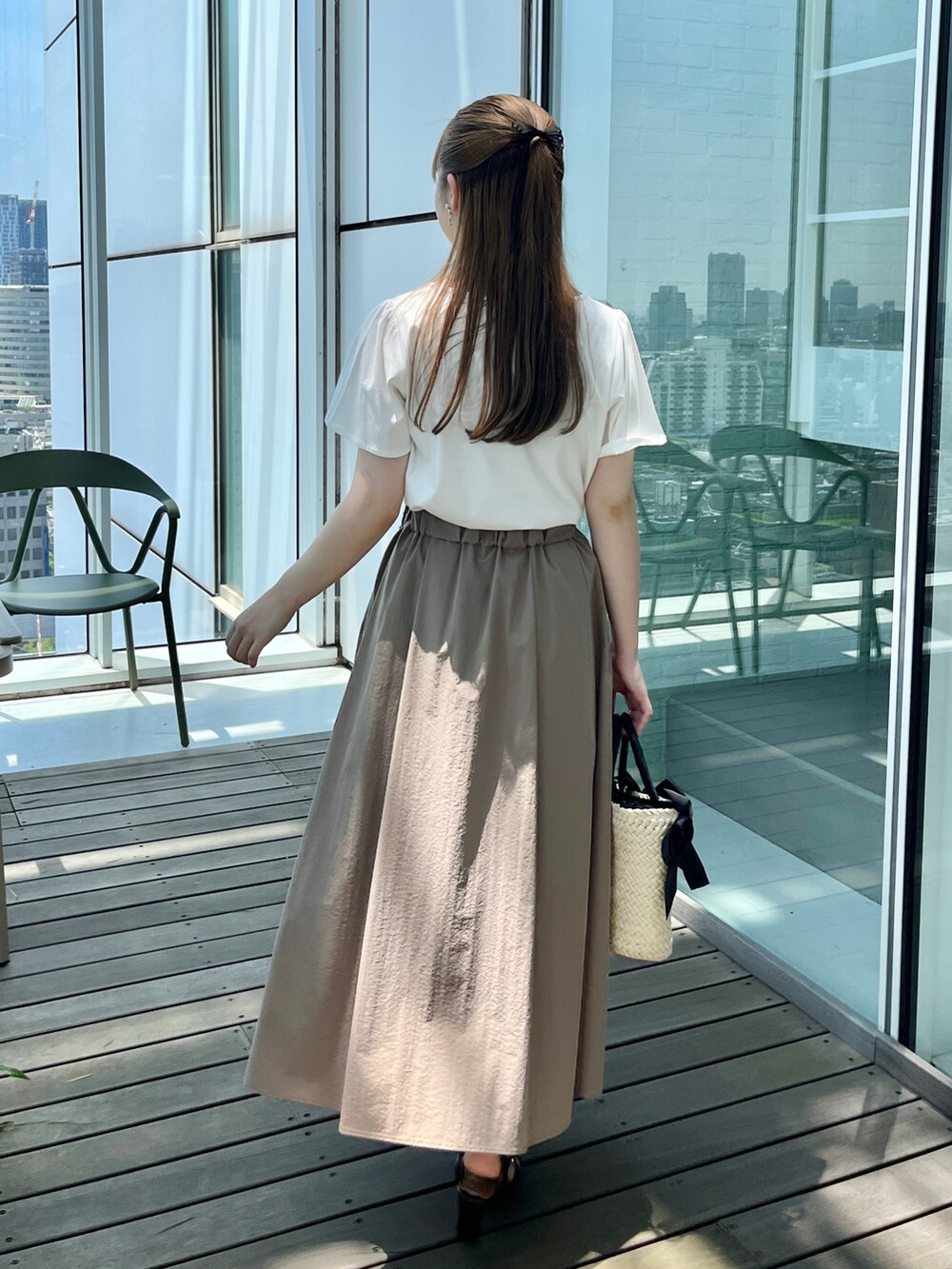 ホワイト系のTシャツ/カットソー、ベージュ系のスカート、ブラック系のハンドバッグを着用したレディースの夏コーディネートの3枚目の写真