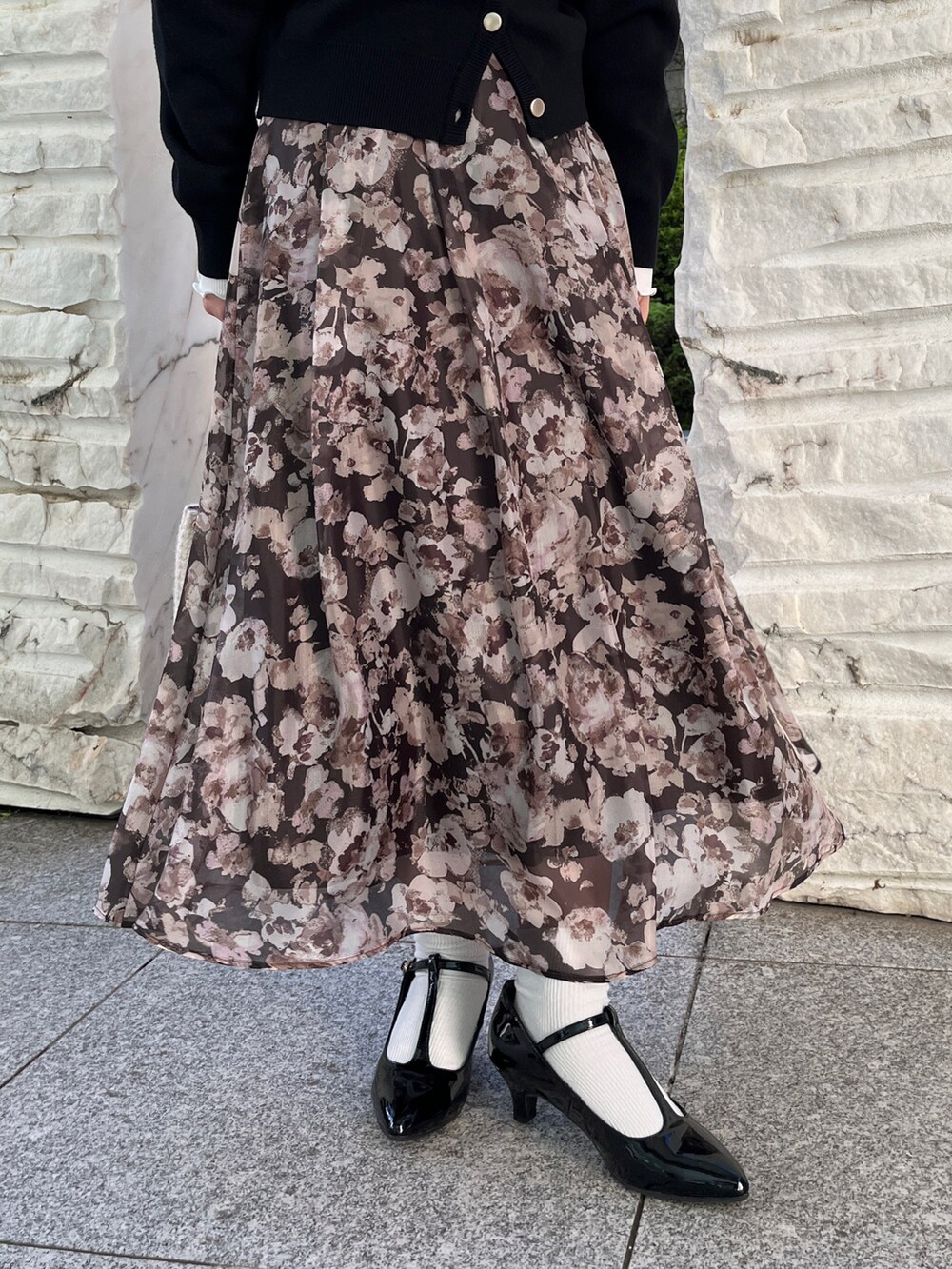 ブラック系のカーディガン/ボレロ、ブラウン系のスカート、ホワイト系のショルダーバッグを着用したレディースの秋コーディネートの5枚目の写真