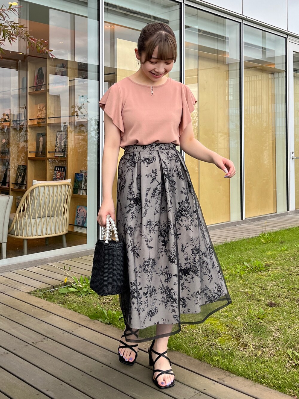 ブラック系のハンドバッグ、ブラック系のサンダル、ピンク系のニット/セーターを着用したレディースの夏コーディネートの4枚目の写真