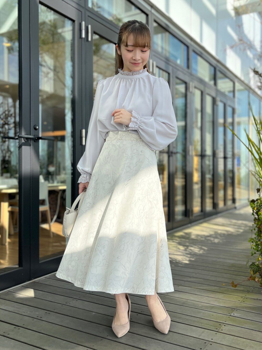 ブラック系のカーディガン/ボレロ、グレー系のシャツ/ブラウス、ベージュ系のスカートを着用したレディースの冬コーディネートの5枚目の写真