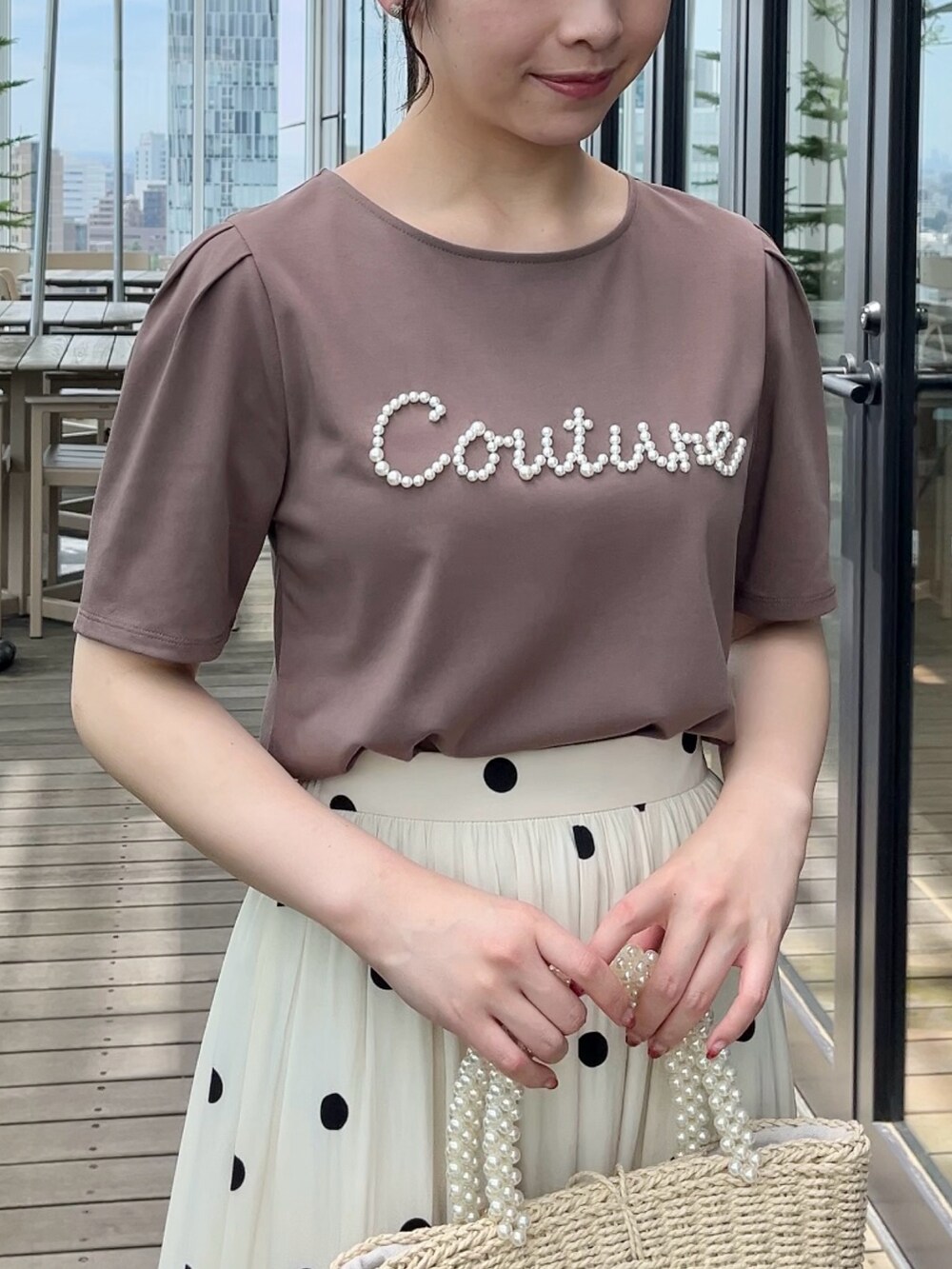 ホワイト系のスカート、ブラウン系のTシャツ/カットソーを着用したレディースの夏コーディネートの4枚目の写真