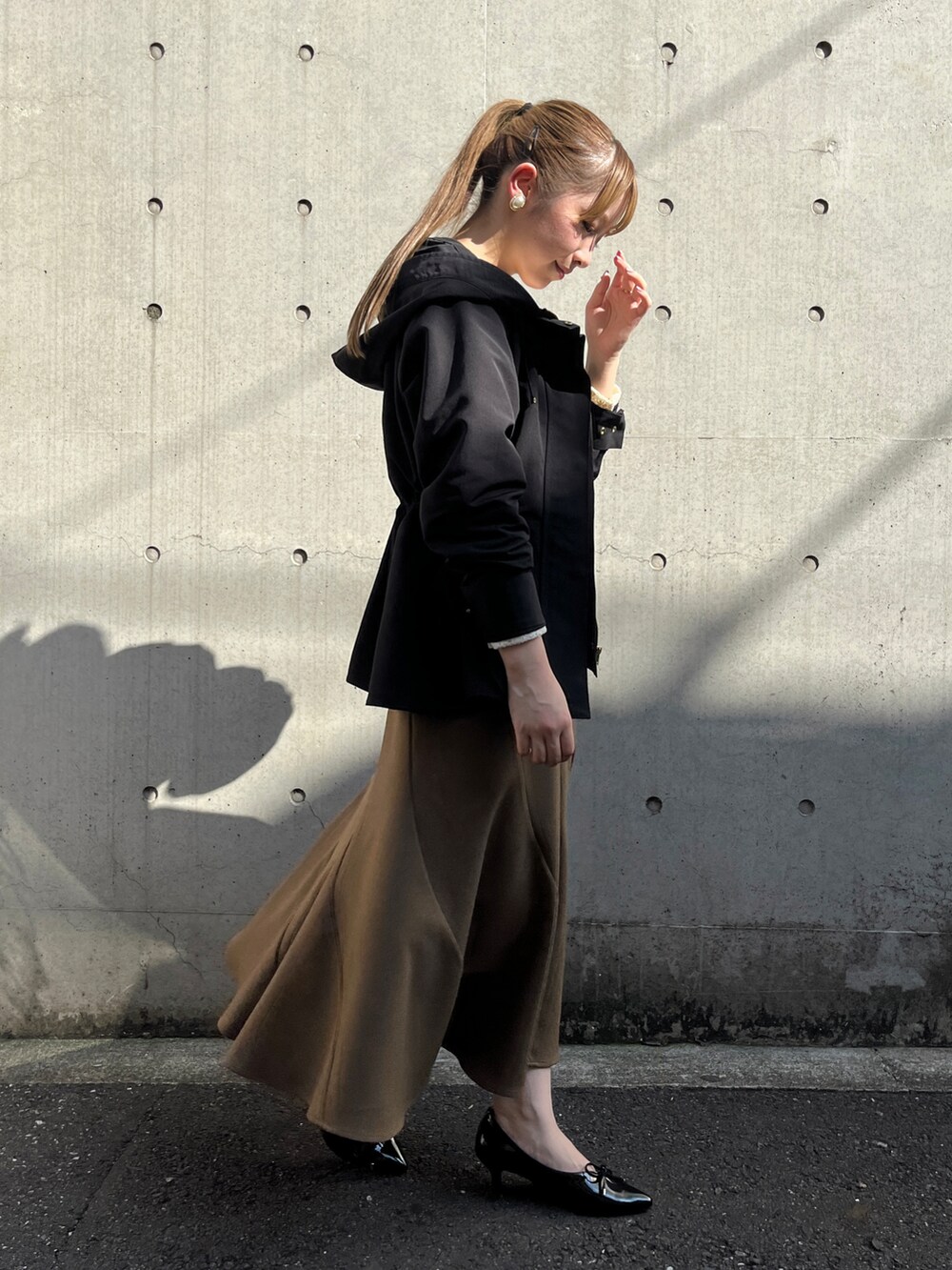 ホワイト系のシャツ/ブラウス、ブラック系のブルゾン、イエロー系のスカートを着用したレディースの秋コーディネートの2枚目の写真