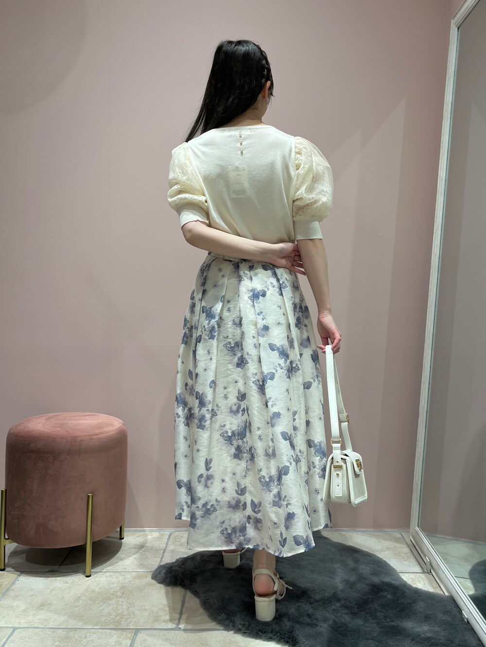 ブルー系のスカート、ホワイト系のニット/セーターを着用したレディースの春コーディネートの2枚目の写真