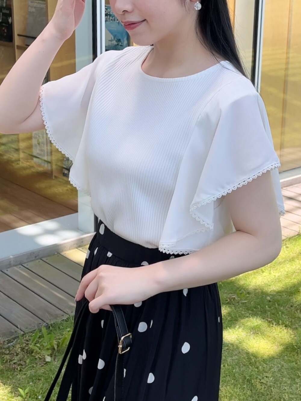 ホワイト系のTシャツ/カットソー、ブラック系のスカートを着用したレディースの夏コーディネートの4枚目の写真