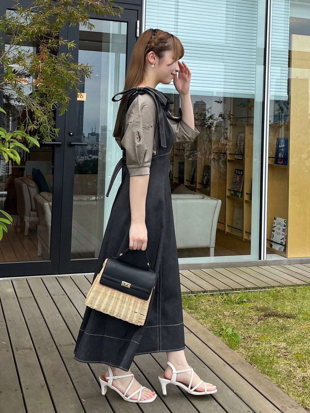 ブラック系のショルダーバッグ、ホワイト系のサンダル、ブラック系のスカートを着用したレディースの夏コーディネートの2枚目の写真