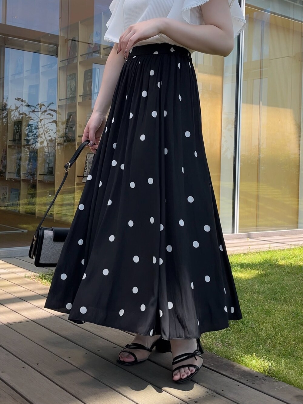 ホワイト系のTシャツ/カットソー、ブラック系のスカートを着用したレディースの夏コーディネートの5枚目の写真