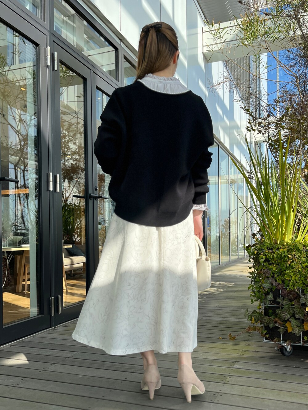 ブラック系のカーディガン/ボレロ、グレー系のシャツ/ブラウス、ベージュ系のスカートを着用したレディースの冬コーディネートの3枚目の写真