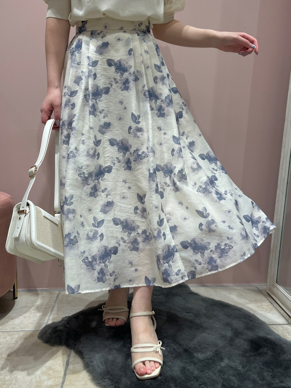 ブルー系のスカート、ホワイト系のニット/セーターを着用したレディースの春コーディネートの5枚目の写真