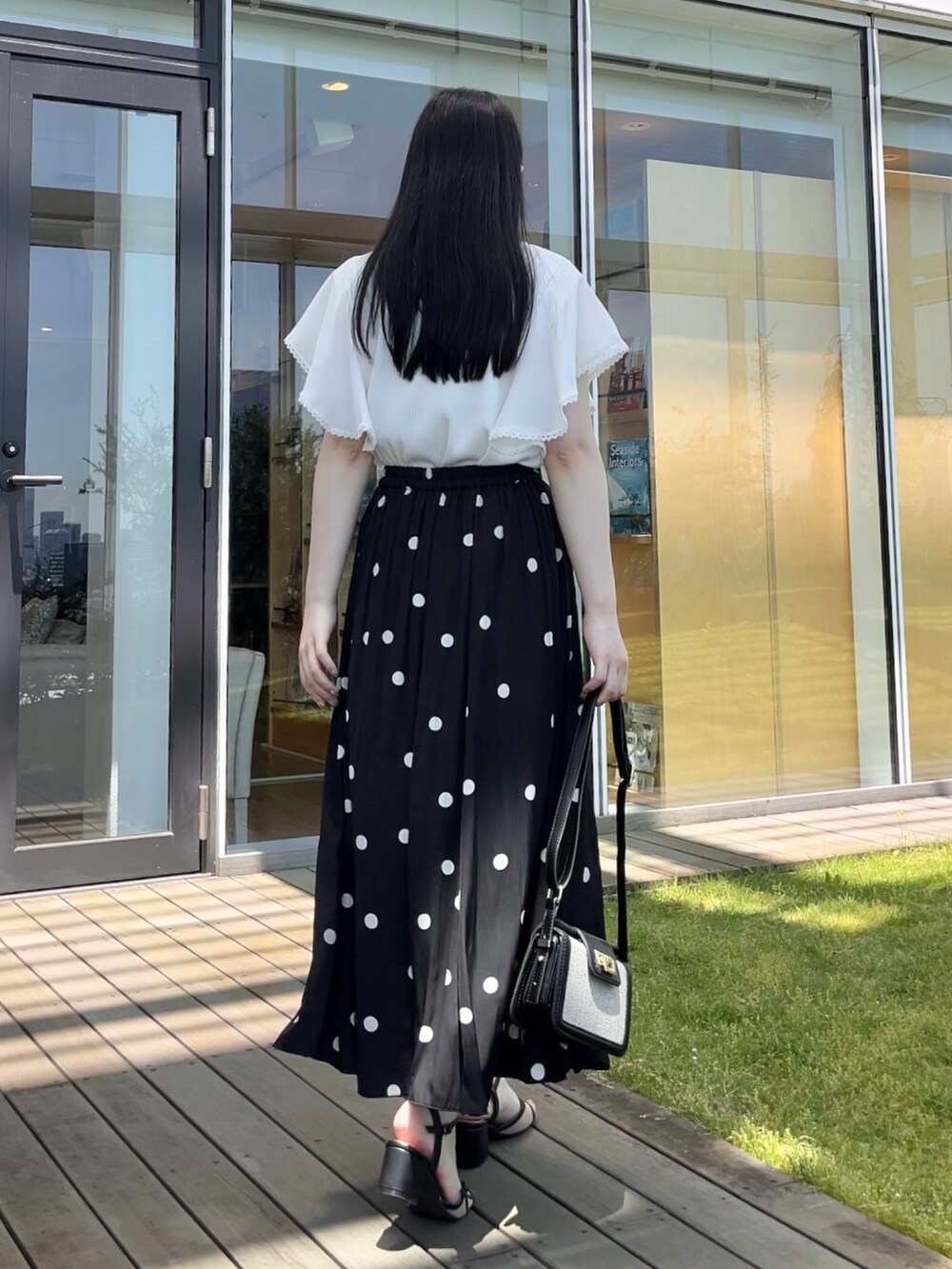 ホワイト系のTシャツ/カットソー、ブラック系のスカートを着用したレディースの夏コーディネートの3枚目の写真