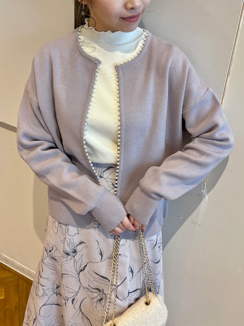 ブルー系のカーディガン/ボレロ、ベージュ系のスカート、ホワイト系のTシャツ/カットソーを着用したレディースの秋コーディネートの4枚目の写真