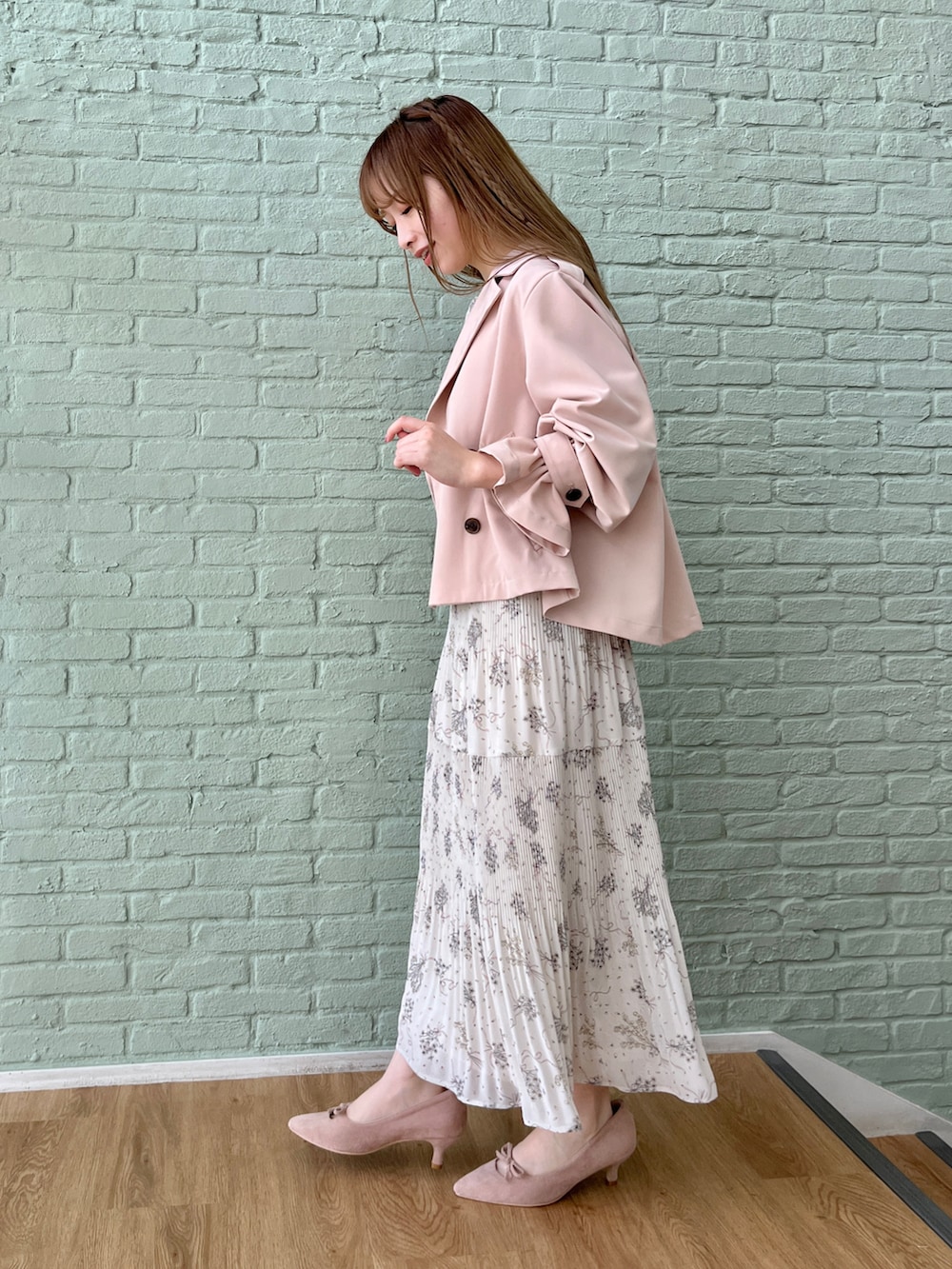 ピンク系のトレンチコート、ベージュ系のワンピースを着用したレディースの冬コーディネートの2枚目の写真