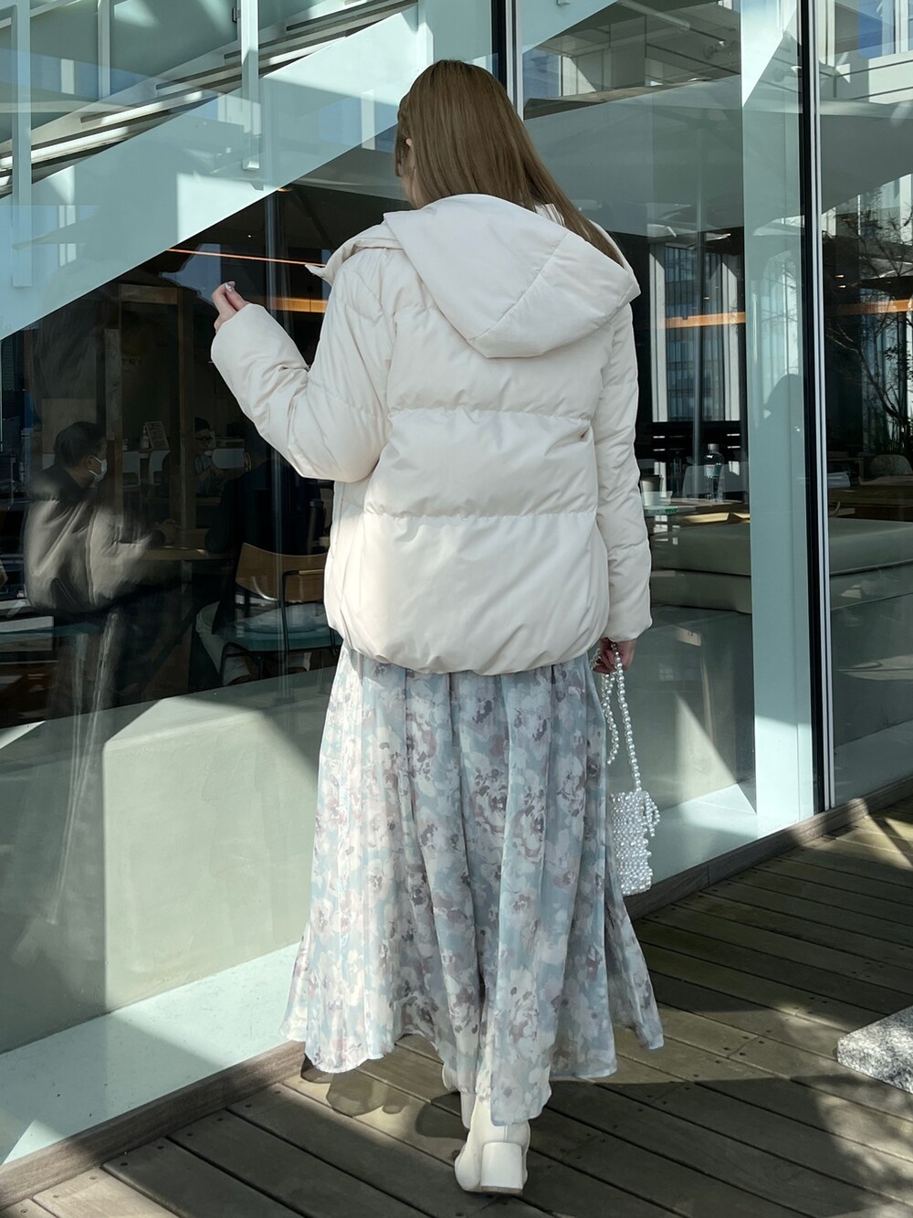 ホワイト系のダウンジャケット/コート、ホワイト系のニット/セーター、グリーン系のスカートを着用したレディースの秋コーディネートの2枚目の写真