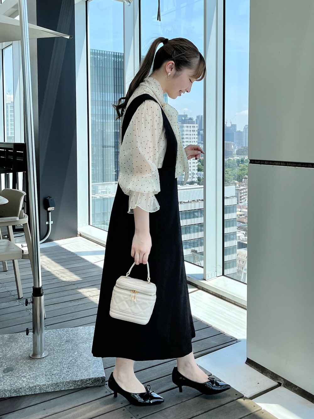 ホワイト系のショルダーバッグ、ベージュ系のワンピースを着用したレディースの秋コーディネートの2枚目の写真