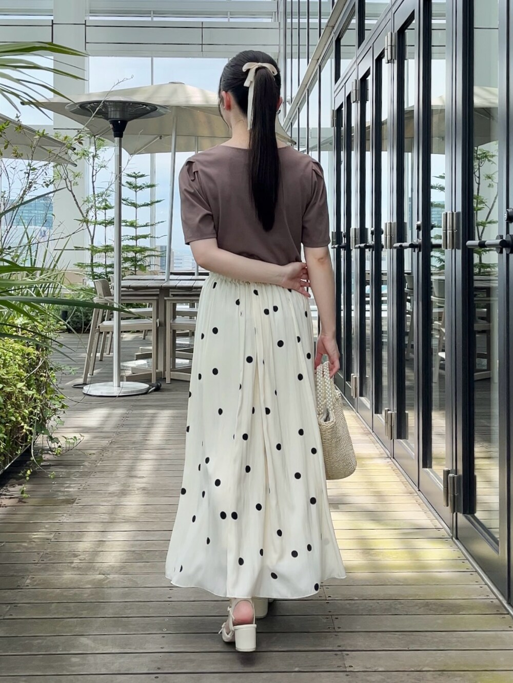 ホワイト系のスカート、ブラウン系のTシャツ/カットソーを着用したレディースの夏コーディネートの3枚目の写真