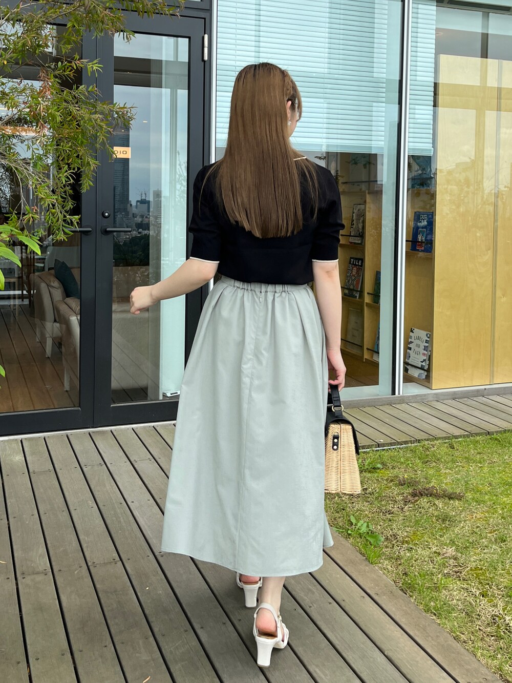 ブラック系のショルダーバッグ、ホワイト系のサンダル、グリーン系のスカートを着用したレディースの夏コーディネートの3枚目の写真