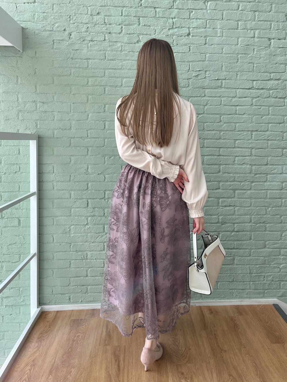 ホワイト系のシャツ/ブラウス、パープル系のスカートを着用したレディースの冬コーディネートの3枚目の写真