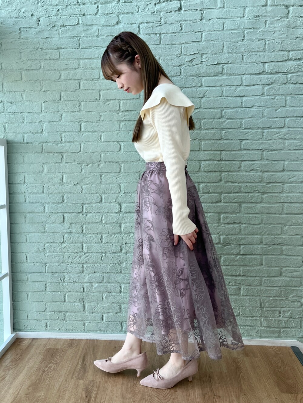 ホワイト系のニット/セーター、パープル系のスカートを着用したレディースの冬コーディネートの2枚目の写真