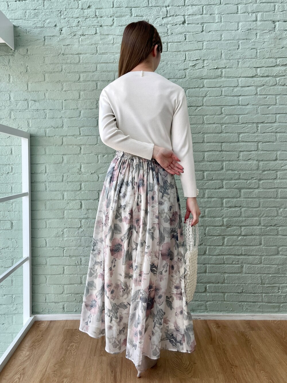 ホワイト系のニット/セーター、ベージュ系のスカートを着用したレディースの冬コーディネートの3枚目の写真