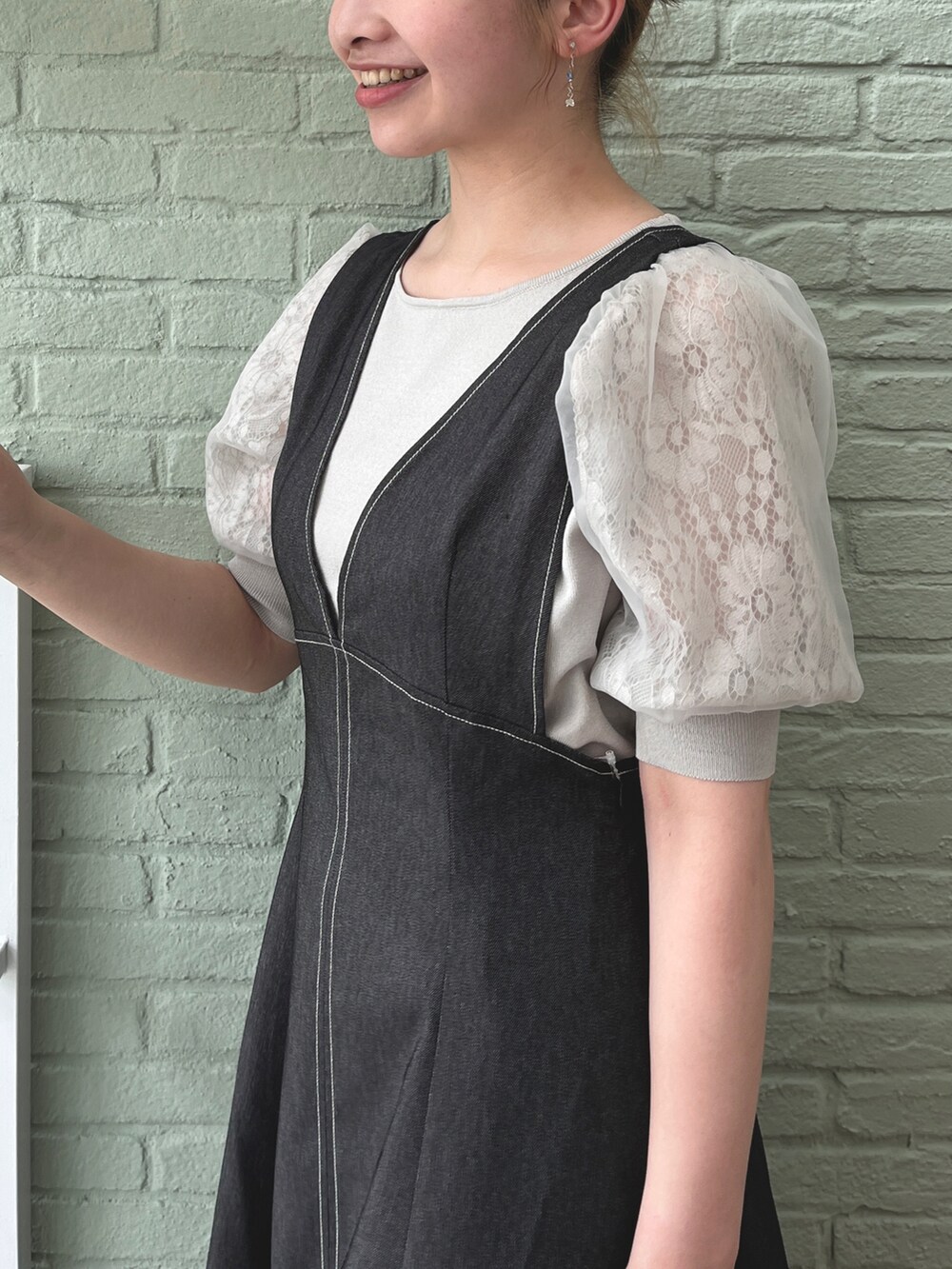 グレー系のニット/セーター、ブラック系のスカート、ブラック系のショルダーバッグを着用したレディースの夏コーディネートの4枚目の写真