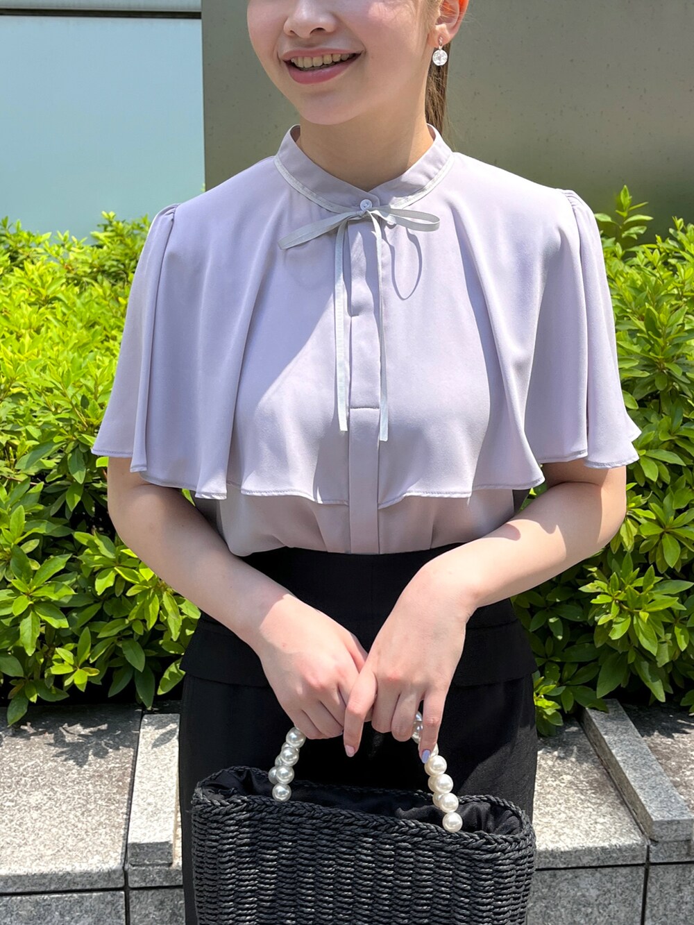 グレー系のシャツ/ブラウス、ブラック系のスカート、ブラック系のハンドバッグを着用したレディースの夏コーディネートの4枚目の写真